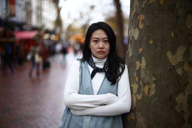 Carmen Lau, Hong Kong pro-democracy activist living in exile in the UK, poses for a photograph in the centre of Reading, west of London, on December 12, 2025. The Hong Kong activist living in exile in the UK said she was "shocked and terrified" after discovering her neighbours received letters containing AI-generated sexually explicit images of her. Lau, like several other high-profile Hong Kong refugees in the UK, found out first earlier this year that her neighbours had been sent letters encouraging them to turn her in to the Chinese embassy, offering rewards of tens of thousands of pounds. (Photo by Henry NICHOLLS / AFP)