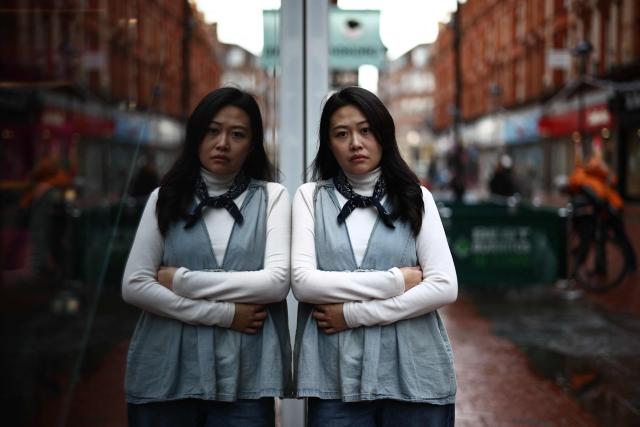 Carmen Lau, Hong Kong pro-democracy activist living in exile in the UK, poses for a photograph in the centre of Reading, west of London, on December 12, 2025. The Hong Kong activist living in exile in the UK said she was "shocked and terrified" after discovering her neighbours received letters containing AI-generated sexually explicit images of her. Lau, like several other high-profile Hong Kong refugees in the UK, found out first earlier this year that her neighbours had been sent letters encouraging them to turn her in to the Chinese embassy, offering rewards of tens of thousands of pounds. (Photo by Henry NICHOLLS / AFP)