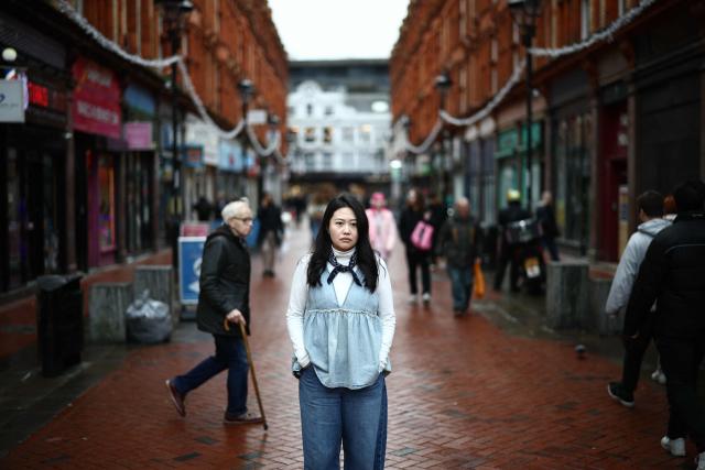 Carmen Lau, Hong Kong pro-democracy activist living in exile in the UK, poses for a photograph in the centre of Reading, west of London, on December 12, 2025. The Hong Kong activist living in exile in the UK said she was "shocked and terrified" after discovering her neighbours received letters containing AI-generated sexually explicit images of her. Lau, like several other high-profile Hong Kong refugees in the UK, found out first earlier this year that her neighbours had been sent letters encouraging them to turn her in to the Chinese embassy, offering rewards of tens of thousands of pounds. (Photo by HENRY NICHOLLS / AFP)