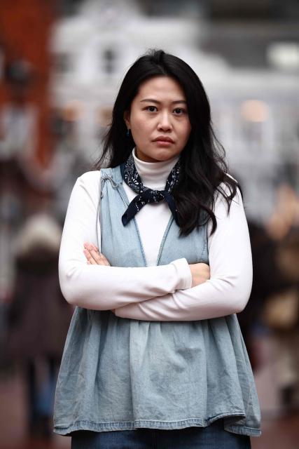 Carmen Lau, Hong Kong pro-democracy activist living in exile in the UK, poses for a photograph in the centre of Reading, west of London, on December 12, 2025. The Hong Kong activist living in exile in the UK said she was "shocked and terrified" after discovering her neighbours received letters containing AI-generated sexually explicit images of her. Lau, like several other high-profile Hong Kong refugees in the UK, found out first earlier this year that her neighbours had been sent letters encouraging them to turn her in to the Chinese embassy, offering rewards of tens of thousands of pounds. (Photo by HENRY NICHOLLS / AFP)