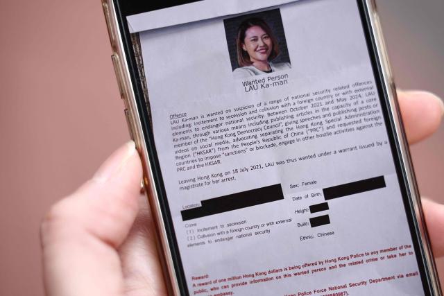 An image displayed on a mobile phone shows one of the letters recieved by the neighbours of Carmen Lau, Hong Kong pro-democracy activist living in exile in the UK, with details redacted on the original, detailing the bounty being offered for her arrest, in the centre of Reading, west of London, on December 12, 2025. The Hong Kong activist living in exile in the UK said she was "shocked and terrified" after discovering her neighbours received letters containing AI-generated sexually explicit images of her. Lau, like several other high-profile Hong Kong refugees in the UK, found out first earlier this year that her neighbours had been sent letters encouraging them to turn her in to the Chinese embassy, offering rewards of tens of thousands of pounds. (Photo by HENRY NICHOLLS / AFP)