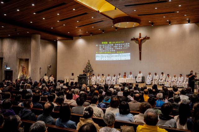 People attend a Mass at the St. Benedict's Church in Hong Kong on December 12, 2025, for the victims of a deadly fire at the Wang Fuk Court residential estate in the Tai Po district. (Photo by Leung Man Hei / AFP)