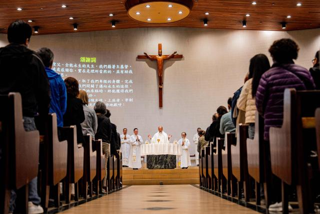 Main celebrant Rev. Raja Duggimpudi (C) prays during a Mass at the St. Benedict's Church in Hong Kong on December 12, 2025, for the victims of a deadly fire at the Wang Fuk Court residential estate in the Tai Po district. (Photo by Leung Man Hei / AFP)