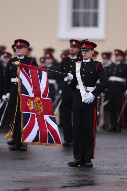 An Officer Cadet holds the sovereign's colours during the No. 251 Sovereign’s Parade at the Royal Military Academy in Sandhurst, southwest of London on December 12, 2025. The parade marks the completion of 44 weeks of intensive training for the Officer Cadets of Commissioning Course 251. (Photo by Adrian Dennis / AFP)
