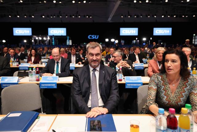 Bavaria's State Premier and leader of the conservative Christian Social Union (CSU) Markus Soeder sits next to German Minister for Research, Technology and Aerospace and member of CSU party Dorothee Baer prior to a congress of the Christian Social Union (CSU) party on December 12, 2025 in Munich, southern Germany. (Photo by Alexandra BEIER / AFP)
