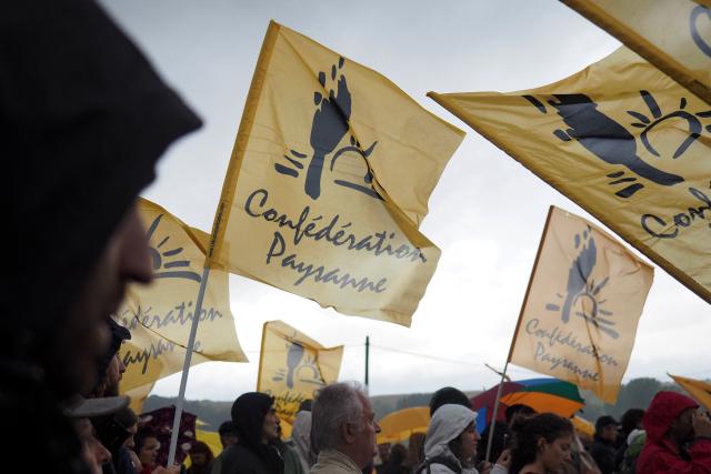 (FILES) Members of French farmers union La Confederation Paysanne gather with flags as they occupate fields belonging to Chinese farmers, during a demonstration against "land grabbing" by Chinese investors, in Murs, near Chatillon-sur-Indre on August 29, 2018. On December 12, the Confйdйration paysanne farmer union is calling for “blockades across France” to protest the government’s approach to contagious nodular dermatitis (CND), as the latter considers the “slaughter” of cattle infected with the disease to be “the only solution” to “save the industry". (Photo by GUILLAUME SOUVANT / AFP)