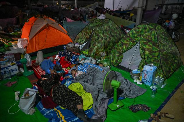 Displaced residents rest at a temporary camp in Banteay Meanchey province on December 12, 2025, amid clashes along the Cambodia-Thailand border. (Photo by TANG CHHIN Sothy / AFP)