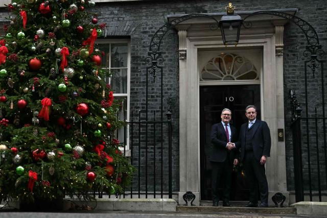 Belgium's Prime Minister Bart de Wever (R) shakes hands with Britain's Prime Minister Keir Starmer (L) outside 10 Downing Street in central London on December 12, 2025, ahead of talks. (Photo by Ben STANSALL / POOL / AFP)