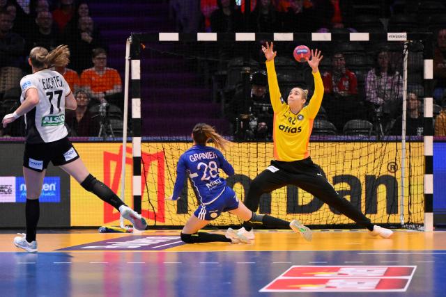 France's right winger #28 Lucie Granier (CL) scores during the IHF Women's Handball World Championship semi final match between France and Germany in Rotterdam Ahoy Arena, in Rotterdam, on December 12, 2025. (Photo by JOHN THYS / AFP)