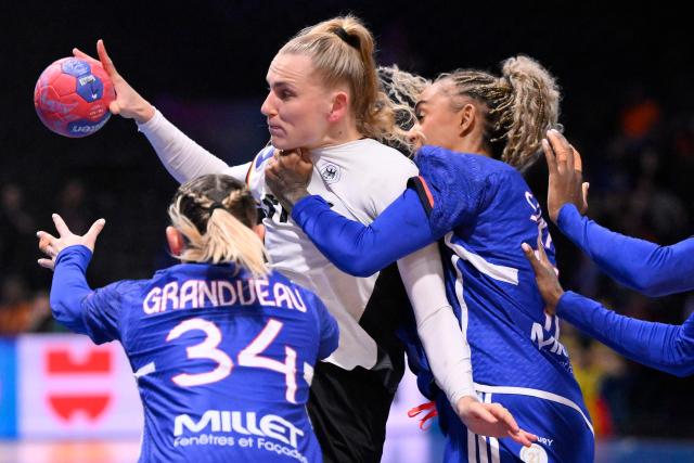 Germany's centre back #23 Annika Lott (2L) passes the ball as she is challenged by France's centre back #34 Lena Grandveau (L) and France's right back #15 Marie-Helene Sajka (R) during the IHF Women's Handball World Championship semi final match between France and Germany in Rotterdam Ahoy Arena, in Rotterdam, on December 12, 2025. (Photo by JOHN THYS / AFP)