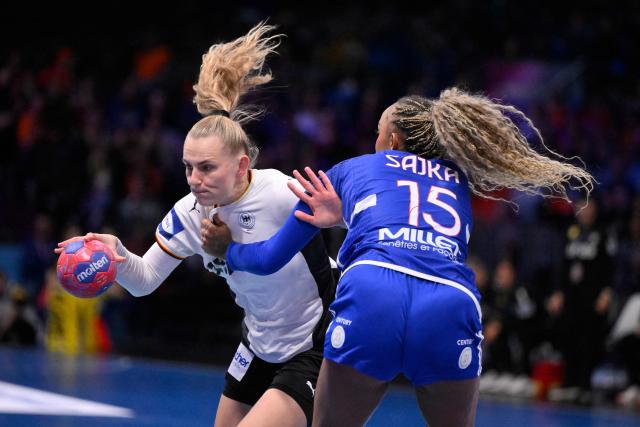 Germany's centre back #23 Annika Lott (L) and France's right back #15 Marie-Helene Sajka (R) fight for the ball during the IHF Women's Handball World Championship semi final match between France and Germany in Rotterdam Ahoy Arena, in Rotterdam, on December 12, 2025. (Photo by JOHN THYS / AFP)