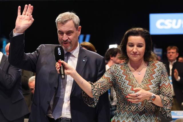 Bavaria's State Premier and leader of the conservative Christian Social Union (CSU) Markus Soeder (L) speaks next to German Minister for Research, Technology and Aerospace and CSU member Dorothee Baer after being reelected during a congress of the Christian Social Union (CSU) party on December 12, 2025 in Munich, southern Germany. Soeder has been confirmed in office with only 83.6 percent approval, his worst result to date at the CSU party conference in Munich. In the last election two years ago, Soeder won 96.6 percent of the delegate votes. (Photo by Alexandra BEIER / AFP)
