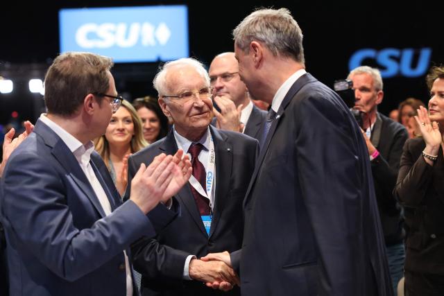 Former Bavarian state minister Edmund Stoiber congratulates Bavaria's State Premier and leader of the conservative Christian Social Union (CSU) Markus Soeder during a congress of the Christian Social Union (CSU) party on December 12, 2025 in Munich, southern Germany. (Photo by Alexandra BEIER / AFP)