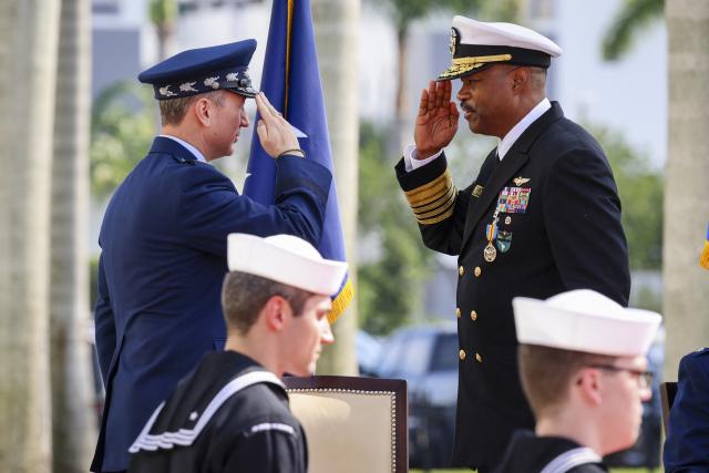 US Air Force Gen. Dan Caine, chairman of the Joint Chiefs of Staff (L), salutes US Navy Adm. Alvin Holsey (R) during his relinquishment of command and retirement ceremony at US Southern Command (SOUTHCOM) headquarters in Doral, Florida, on December 12, 2025. The US admiral responsible for overseeing a major military buildup in the Caribbean and controversial strikes on alleged drug-smuggling boats stepped down on Friday just a year into his tenure. (Photo by Eva Marie UZCATEGUI / AFP)