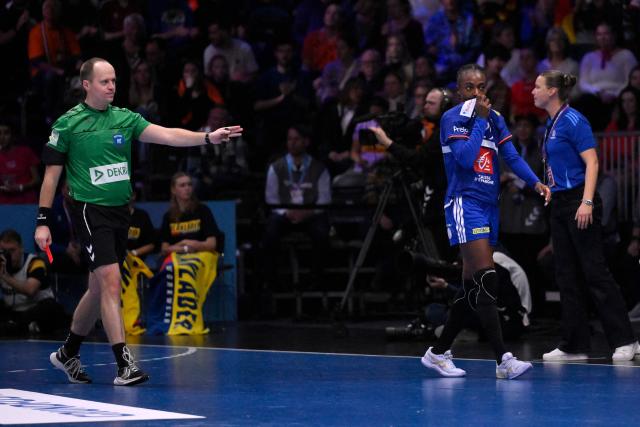 France's pivot #29 Oriane Ondono (2R) is shown to the sidelines after receiving a red card during the IHF Women's Handball World Championship semi final match between France and Germany in Rotterdam Ahoy Arena, in Rotterdam, on December 12, 2025. (Photo by JOHN THYS / AFP)