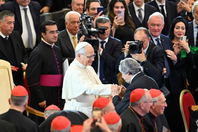 Conductor Riccardo Muti kisses the hand of Pope Leo XIV as he receives the Ratzinger Prize 2025 during a Christmas concert, at Paul-VI audience hall in The Vatican on December 12, 2025. (Photo by Tiziana FABI / AFP)
