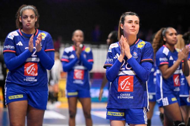 France's right winger #28 Lucie Granier (CR) reacts as she acknowledges the crowd with teammates at the end of the IHF Women's Handball World Championship semi final match between France and Germany in Rotterdam Ahoy Arena, in Rotterdam, on December 12, 2025. (Photo by JOHN THYS / AFP)