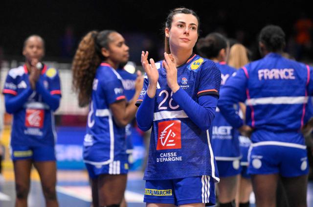 France's right winger #28 Lucie Granier (C) acknowledges the crowd at the end of the IHF Women's Handball World Championship semi final match between France and Germany in Rotterdam Ahoy Arena, in Rotterdam, on December 12, 2025. (Photo by JOHN THYS / AFP)