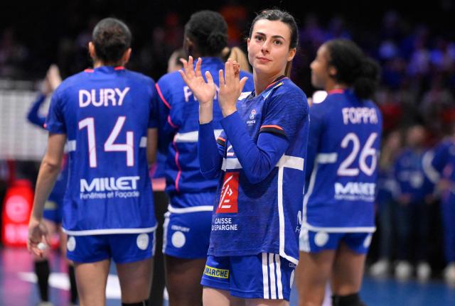France's right winger #28 Lucie Granier (C) reacts at the end of the IHF Women's Handball World Championship semi final match between France and Germany in Rotterdam Ahoy Arena, in Rotterdam, on December 12, 2025. (Photo by JOHN THYS / AFP)