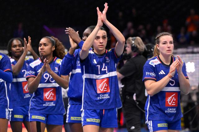France's wing #14 Nina Dury (C) reacts as she acknowledges the crowd with teammates at the end of the IHF Women's Handball World Championship semi final match between France and Germany in Rotterdam Ahoy Arena, in Rotterdam, on December 12, 2025. (Photo by JOHN THYS / AFP)