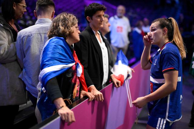 France's left back #05 Clarisse Mairot (R) reacts as she talks with supporters in the stands at the end of the IHF Women's Handball World Championship semi final match between France and Germany in Rotterdam Ahoy Arena, in Rotterdam, on December 12, 2025. (Photo by JOHN THYS / AFP)
