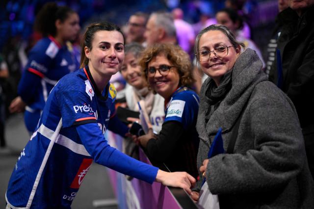 France's right winger #28 Lucie Granier (L) poses for a photograph at the end of the IHF Women's Handball World Championship semi final match between France and Germany in Rotterdam Ahoy Arena, in Rotterdam, on December 12, 2025. (Photo by JOHN THYS / AFP)