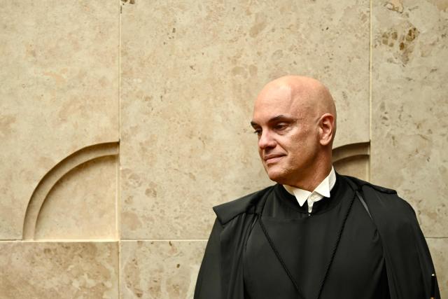 (FILES) Brazil's Federal Supreme Court (STF) minister Alexandre de Moraes gestures during a ceremony where Judge Edson Fachin took office as Chief Justice and Moraes as Deputy Chief Justice, in Brasilia on September 29, 2025. The US Treasury Department lifted sanctions on December 12, 2025 on de Moraes, who oversaw a trial of his country's former president Jair Bolsonaro and was sanctioned in July was originally sanctioned in July, followed by measures against his wife, Viviane Barci de Moraes. Both sanctions have since been eased, as the countries move to repair tense relations. (Photo by Evaristo Sa / AFP)