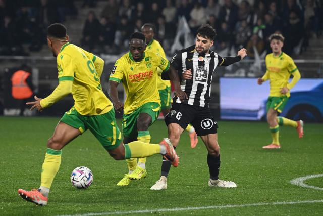 FC Nantes' Colombian defender #27 Deiver Machado (L) fight for the ball with Angers' French midfielder #06 Louis Mouton (R) during the French L1 football match between SCO Angers and FC Nantes at the Raymond-Kopa stadium in Angers, western France, on December 12, 2025. (Photo by JEAN-FRANCOIS MONIER / AFP)