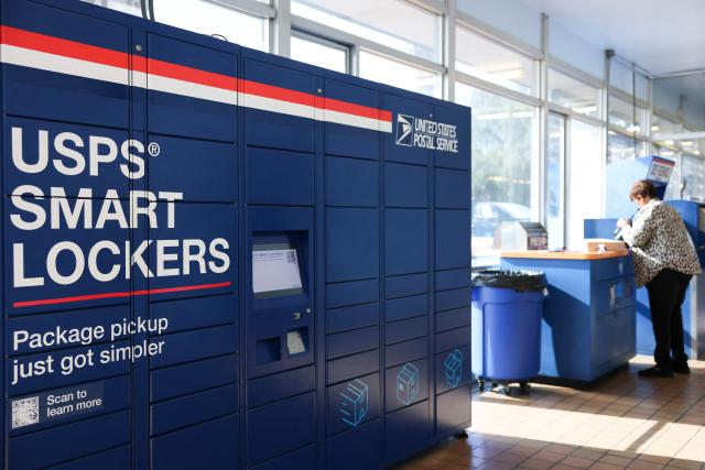 USPS Smart Lockers for package pickup stand in the lobby of the United States Postal Service (USPS) Gardena Post Office in Gardena, California, on December 12, 2025. The USPS reported an increase in expanded daily processing capacity from 60 million to 88 million packages nationwide by deploying more than 600 package sorters, with over 6 billion pieces of mail and packages accepted this holiday season. (Photo by Patrick T. Fallon / AFP)