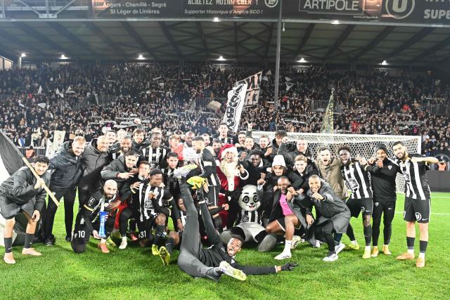 Angers SCO players celebrate their victory at the end of the French L1 football match between SCO Angers and FC Nantes at the Raymond-Kopa Stadium in Angers, western France, on December 12, 2025. (Photo by JEAN-FRANCOIS MONIER / AFP)