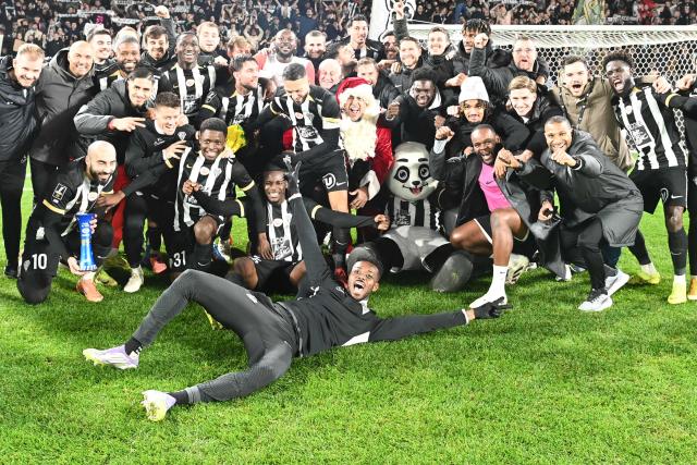 Angers SCO players celebrate their victory at the end of the French L1 football match between SCO Angers and FC Nantes at the Raymond-Kopa Stadium in Angers, western France, on December 12, 2025. (Photo by JEAN-FRANCOIS MONIER / AFP)