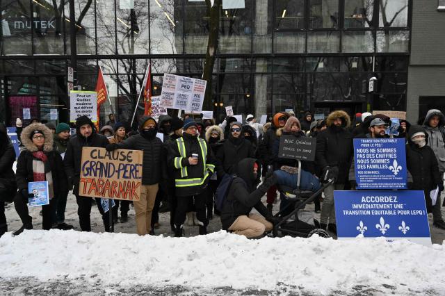 Pro immigration demonstrators protest in front of the Quebec Immigration Ministry in downtown Montreal, Canada, on December 12, 2025. Hundreds of protesters are calling on the Quebec government to allow immigrants already living in the province to stay, after the cancellation of a program that had allowed temporary workers to immigrate and obtain a pathway to permanent residency. (Photo by Daphné LEMELIN / AFP)