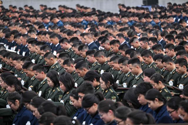 Attendees pay their respects during a ceremony to mark China's National Memorial Day for Nanjing Massacre Victims in Nanjing, in China's eastern Jiangsu province on December 13, 2025. (Photo by Hector RETAMAL / AFP)