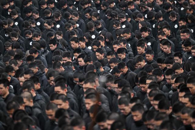 Attendees pay their respects during a ceremony to mark China's National Memorial Day for Nanjing Massacre Victims in Nanjing, in China's eastern Jiangsu province on December 13, 2025. (Photo by Hector RETAMAL / AFP)