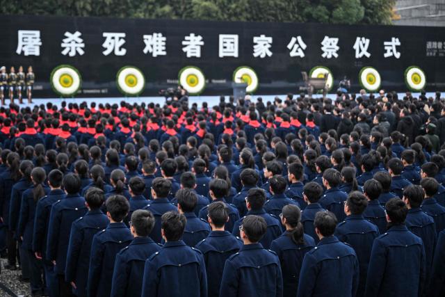 Attendees pay their respects during a ceremony to mark China's National Memorial Day for Nanjing Massacre Victims in Nanjing, in China's eastern Jiangsu province on December 13, 2025. (Photo by Hector RETAMAL / AFP)