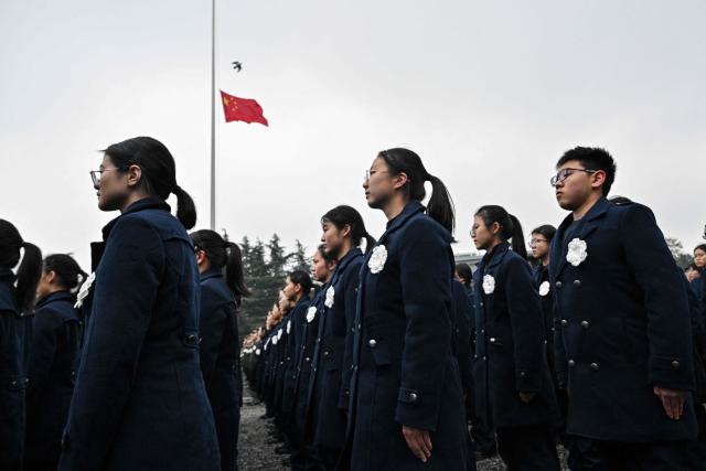 Attendees pay their respects during a ceremony to mark China's National Memorial Day for Nanjing Massacre Victims in Nanjing, in China's eastern Jiangsu province on December 13, 2025. (Photo by Hector RETAMAL / AFP)