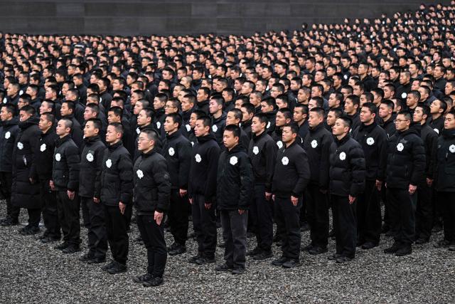 Attendees pay their respects during a ceremony to mark China's National Memorial Day for Nanjing Massacre Victims in Nanjing, in China's eastern Jiangsu province on December 13, 2025. (Photo by Hector RETAMAL / AFP)