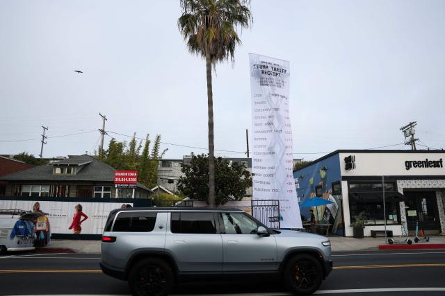 A 40-foot-long banner, depicting a purchase receipt, is displayed by the progressive organization MoveOn to protest against US President Donald Trump's tariffs on imports, in Los Angeles, California, on December 12, 2025. (Photo by Patrick T. Fallon / AFP)