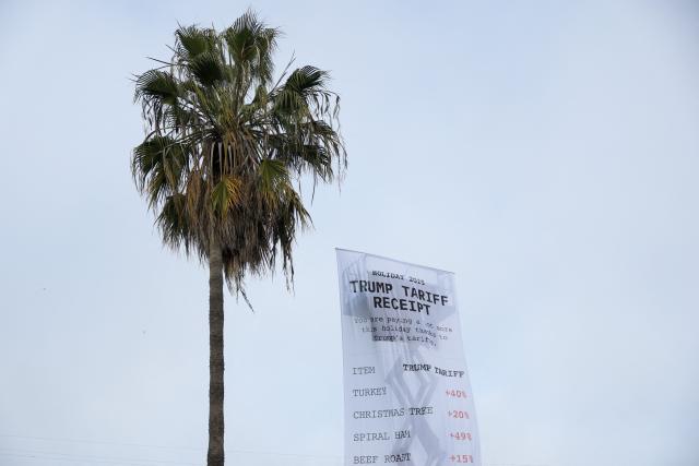 A 40-foot-long banner, depicting a purchase receipt, is displayed by the progressive organization MoveOn to protest against US President Donald Trump's tariffs on imports, in Los Angeles, California, on December 12, 2025. (Photo by Patrick T. Fallon / AFP)
