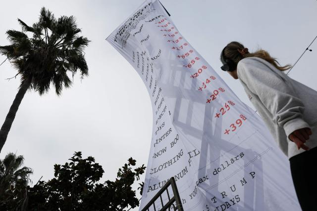A 40-foot-long banner, depicting a purchase receipt, is displayed by the progressive organization MoveOn to protest against US President Donald Trump's tariffs on imports, in Los Angeles, California, on December 12, 2025. (Photo by Patrick T. Fallon / AFP)