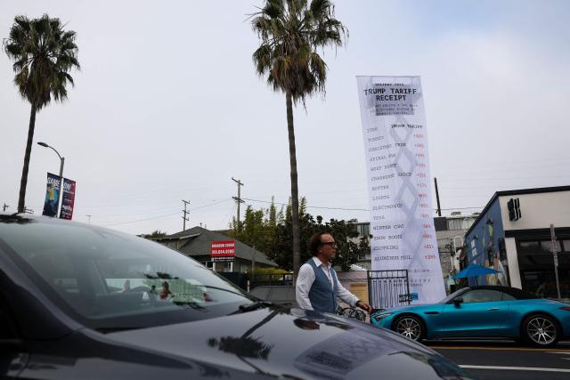 A 40-foot-long banner, depicting a purchase receipt, is displayed by the progressive organization MoveOn to protest against US President Donald Trump's tariffs on imports, in Los Angeles, California, on December 12, 2025. (Photo by Patrick T. Fallon / AFP)