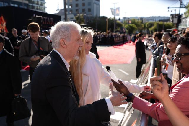 Avatar director James Cameron (L) and his wife Suzy Cameron speak to the media on the red carpet during the Australasian premiere of Avatar Fire and Ash in Wellington on December 13, 2025. (Photo by Marty MELVILLE / AFP)