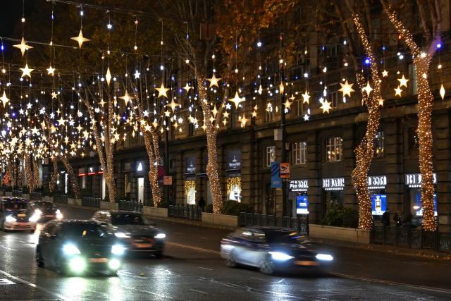 Cars drive along the street decorated with Christmas illuminations in Tbilisi on December 12, 2025. (Photo by Vano SHLAMOV / AFP)