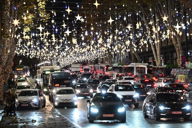 Cars drive along the street decorated with Christmas illuminations in Tbilisi on December 12, 2025. (Photo by Vano SHLAMOV / AFP)