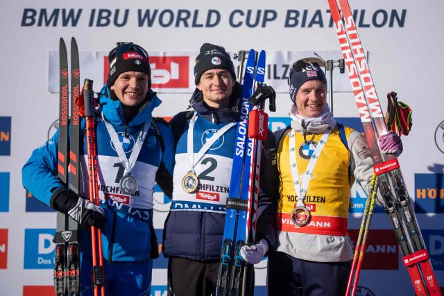 (L-R) Second placed Italy's Tommaso Giacomel, first placed France's Eric Perrot and third placed Norway's Johan-Olav Botn celebrate after winning the men's 12,5km pursuit event of the IBU Biathlon World Cup in Hochfilzen, Austria on December 13, 2025. (Photo by GEORG HOCHMUTH / APA / AFP) / Austria OUT