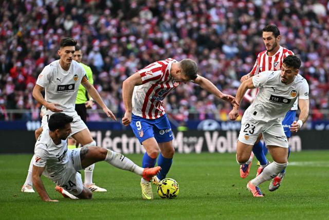 Atletico Madrid's Norwegian forward #09 Alexander Sorloth fights for the ball with Valencia's Swiss defender # 24 Eray Comert (L) during the Spanish league football match between Club Atletico de Madrid and Valencia CF at Metropolitano Stadium in Madrid on December 13, 2025. (Photo by Javier SORIANO / AFP)