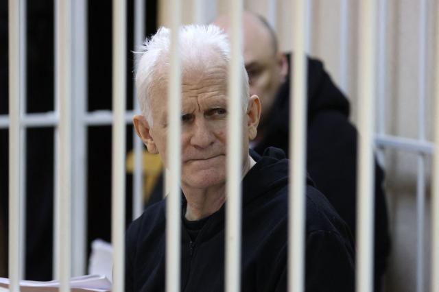 (FILES) Nobel Prize winner Ales Bialiatski is seen in the defendants' cage in the courtroom at the start of the hearing in Minsk on January 5, 2023. Belarus has freed 123 prisoners, including protest leader Maria Kalesnikava and Nobel Peace Prize laureate Ales Bialiatski, rights groups and state media reported on December 13, 2025, after the US envoy earlier said Washington was lifting sanctions on Belarusian potassium. (Photo by Vitaly PIVOVARCHIK / BELTA / AFP) / Belarus OUT