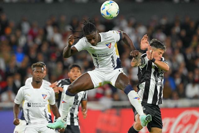 (FILES) Liga de Quito's Haitian defender #04 Ricardo Ade heads the ball past Central Cordoba's midfielder #12 Leonardo Heredia during the Copa Libertadores group stage football match between Ecuador's Liga de Quito and Argentina's Central Cordoba, at the Rodrigo Paz Delgado stadium in Quito, on May 28, 2025. “Free the country, we want to live in peace,” said Ricardo Ade, a member of the Haitian national team that will compete in the World Cup in the United States, who made this appeal to the violent gangs that have caused a crisis in his impoverished nation. (Photo by Rodrigo BUENDIA / AFP)