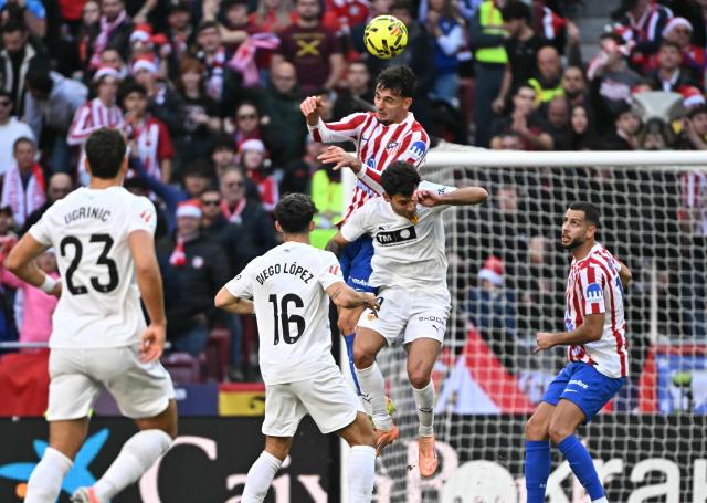 Atletico Madrid's Italian defender #03 Matteo Ruggeri heads the ball during the Spanish league football match between Club Atletico de Madrid and Valencia CF at Metropolitano Stadium in Madrid on December 13, 2025. (Photo by Javier SORIANO / AFP)