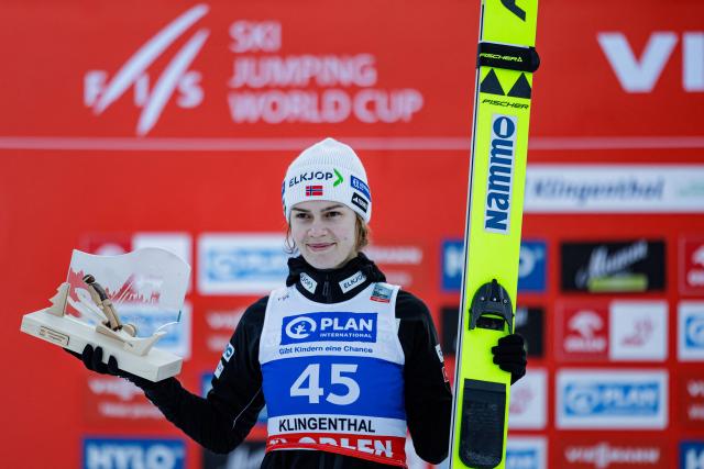 TOPSHOT - Third placed Norway's Anna Odine Stroem celebrates on the podium after winning in the Women's Individual Large Hill HS140 event of the FIS Ski Jumping World Cup in Klingenthal, eastern Germany on December 13, 2025. (Photo by JENS SCHLUETER / AFP)